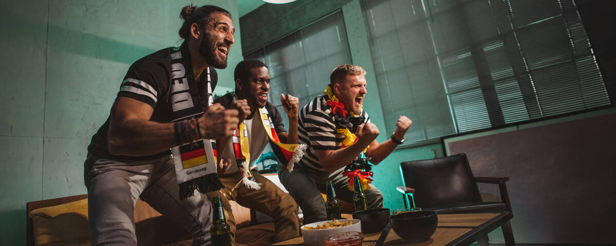 Freunde schauen sich die Fußballmeisterschaft zu Hause an.