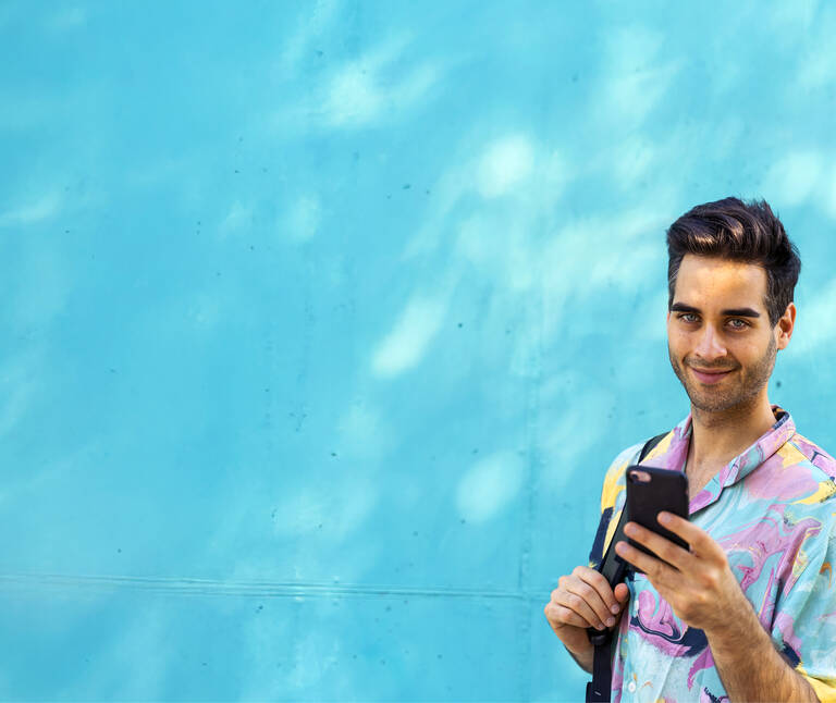 Ein Mann surfet mit seinem eSIM-Tarif am Handy