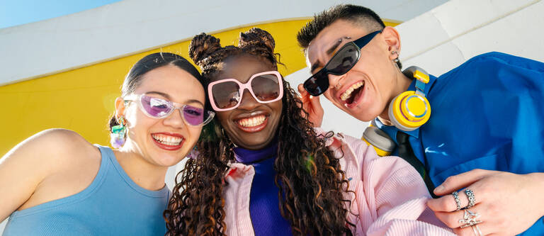 Drei Freunde schauen gemeinsam auf ein Smartphone