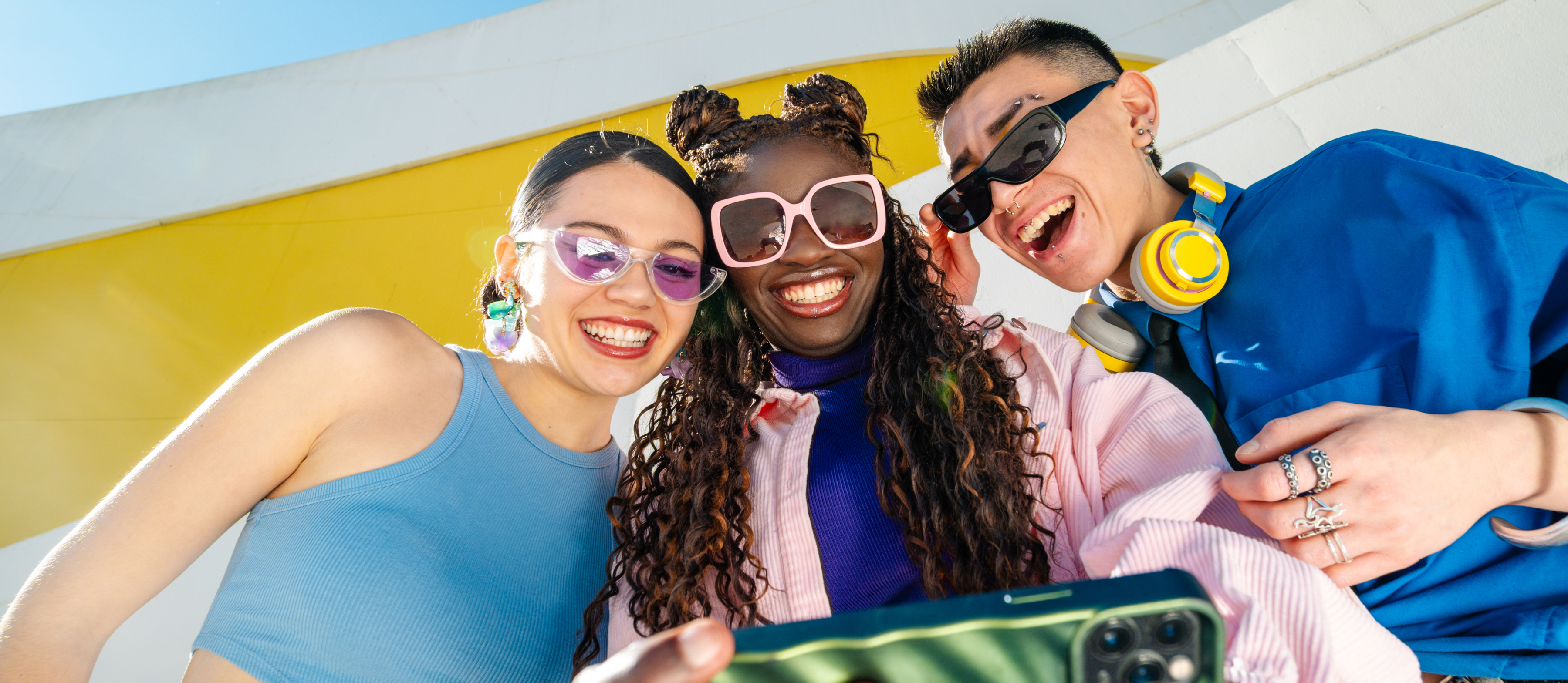 Drei Freunde schauen gemeinsam auf ein Smartphone