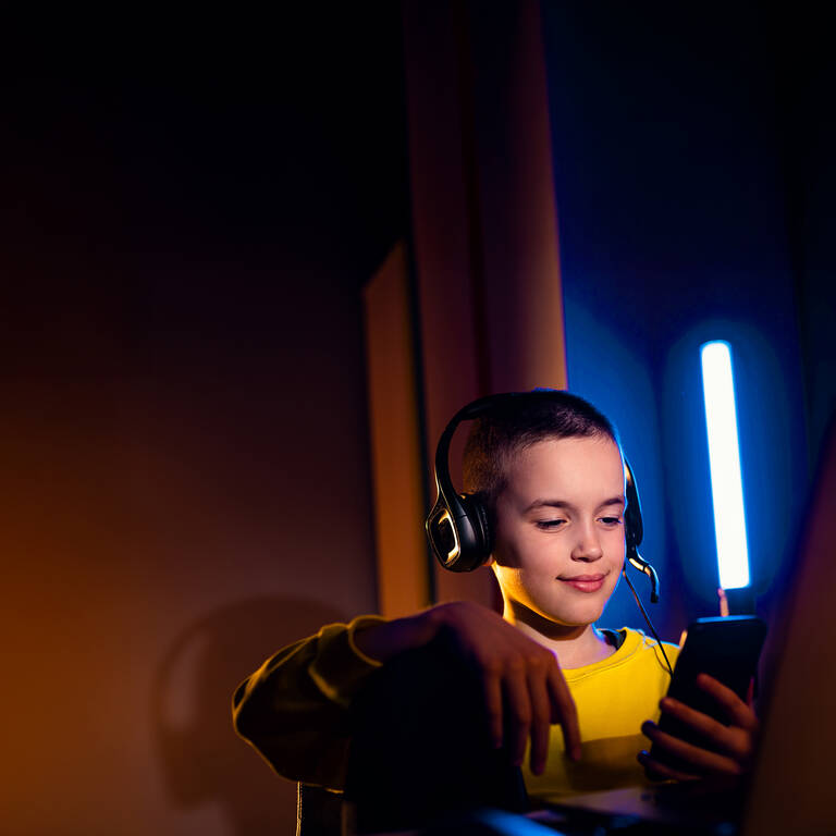 Ein Junge nutzt sein Handy mit einer SIM-Karte für Kinder